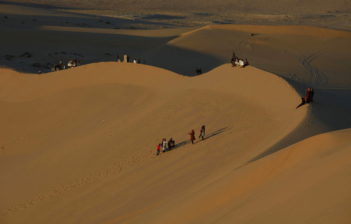 Người dân đi bộ trên sa mạc gần thị trấn ốc đảo Ghadames ngày 19/4/2013. Ghadames là một trị trấn nhỏ với khoảng 11.000 người nằm ở biên giới phía tây của Libya và Algeria. Đây là một địa điểm du lịch có tiếng trước khi cuộc nổi dậy xảy ra. Hiện nay, nó trở nên vắng lặng vì khách nước ngoài bị cấm đặt chân tới đây do tình trạng an ninh bất ổn. Người dân đi bộ trên sa mạc gần thị trấn ốc đảo Ghadames ngày 19/4/2013. Ghadames là một trị trấn nhỏ với khoảng 11.000 người nằm ở biên giới phía tây của Libya và Algeria. Đây là một địa điểm du lịch có tiếng trước khi cuộc nổi dậy xảy ra. Hiện nay, nó trở nên vắng lặng vì khách nước ngoài bị cấm đặt chân tới đây do tình trạng an ninh bất ổn.