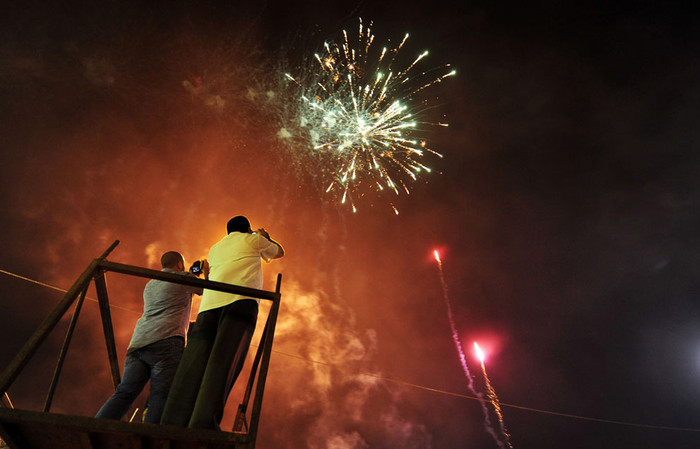 Hai người đàn ông chụp ảnh pháo hoa được bắn để ăn mừng Benghazi gỡ lệnh cấm các nhân vật cấp cao của chế độ cũ tham gia hoạt động chính trị hôm 6/5/2013. Hai người đàn ông chụp ảnh pháo hoa được bắn để ăn mừng Benghazi gỡ lệnh cấm các nhân vật cấp cao của chế độ cũ tham gia hoạt động chính trị hôm 6/5/2013.