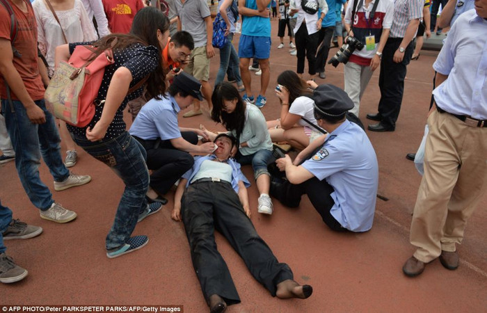 Nữ cảnh sát được đồng đội và các sinh viên giúp đỡ sau khi bị thương trong đám đông.