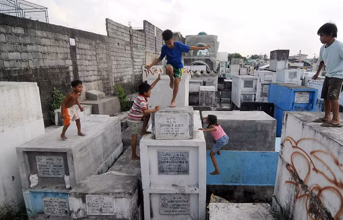 Trẻ em Philippines nô đùa trên những ngôi mộ.