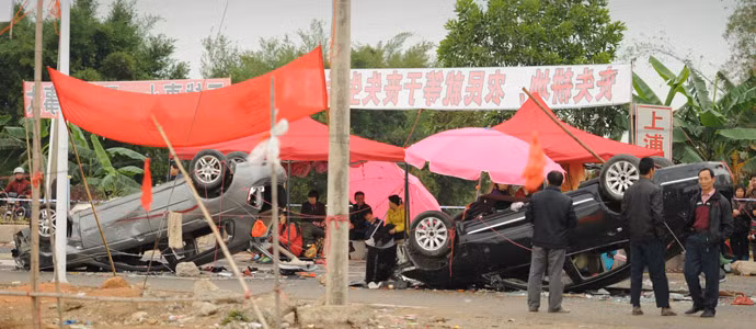 Nhiều xe hơi bị lật nằm rải rác trên đường làng.