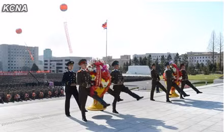 Hai lẵng hoa lớn của nhà lãnh đạo Kim Jong-un có ghi dòng chữ "Đồng chí Kim Nhật Thành và Kim Jong-il sẽ sống mãi trong lòng chúng ta".