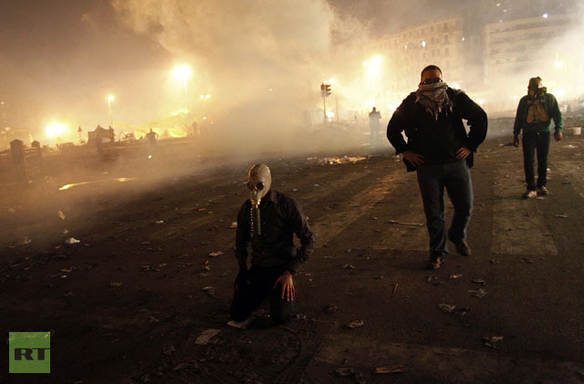 Những người biểu tình đeo mặt nạ tự chế đối phó với đạn hơi cay của cảnh sát chống bạo động ở Cairo.