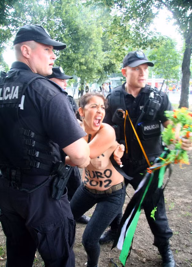 Các nhân viên an ninh bắt giữ người đẹp ngực trần