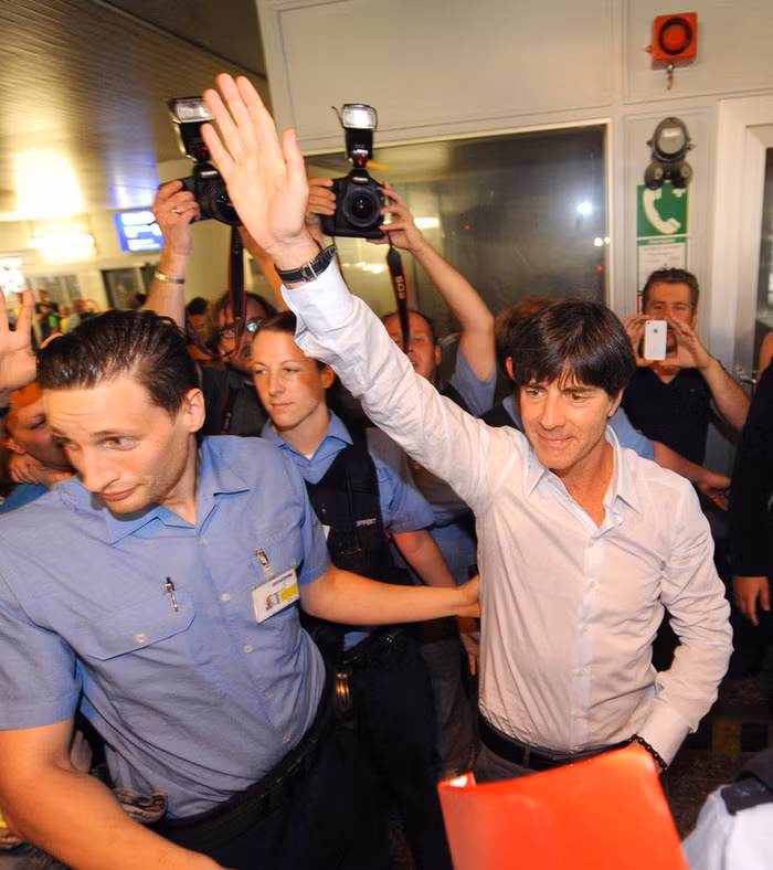 HLV Joachim Low được các nhân viên an ninh hộ tống lên máy bay