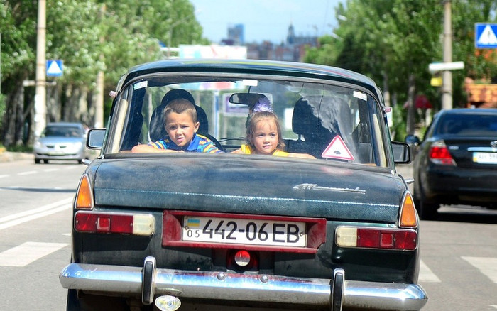 Trẻ em nhìn qua cửa kính ô tô đang đi trên đường phố Donetsk, Ukraina. Trẻ em nhìn qua cửa kính ô tô đang đi trên đường phố Donetsk, Ukraina.
