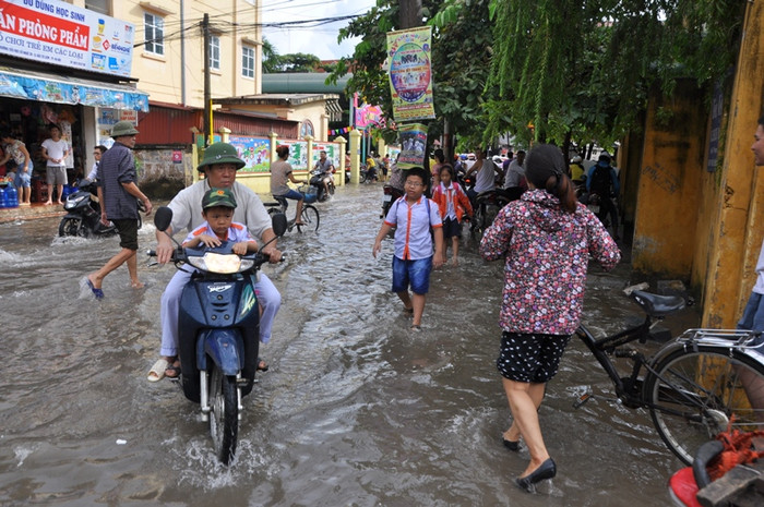 Một em học sinh phải mặc quần soóc lội nước cho khỏi ướt Một em học sinh phải mặc quần soóc lội nước cho khỏi ướt