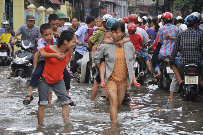 Hai phụ huynh vừa cõng con lội nước vừa trò chuyện. Giữa thủ đô Hà Nội, lội nước tưởng chuyện lạ mà có thật Hai phụ huynh vừa cõng con lội nước vừa trò chuyện. Giữa thủ đô Hà Nội, lội nước tưởng chuyện lạ mà có thật