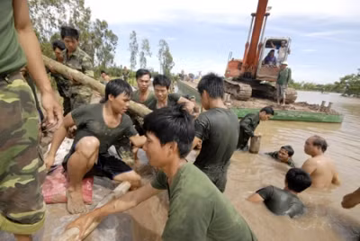 Bí thư huyện Hồng Ngự (người cởi trần ngoài cùng) tham gia đắp đê cứu dân