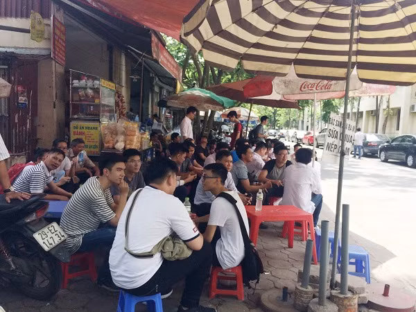 Dưới thời tiết nóng bức, trong lúc chờ con em mình nghe phổ biến quy chế, các vị phụ huynh ngồi tạm vào những hàng nước ven đường để tránh nắng nóng cũng như cùng nhau chia sẻ những câu chuyện về kỳ thi trung học phổ thông quốc gia năm nay (Ảnh: Ngọc Bích)