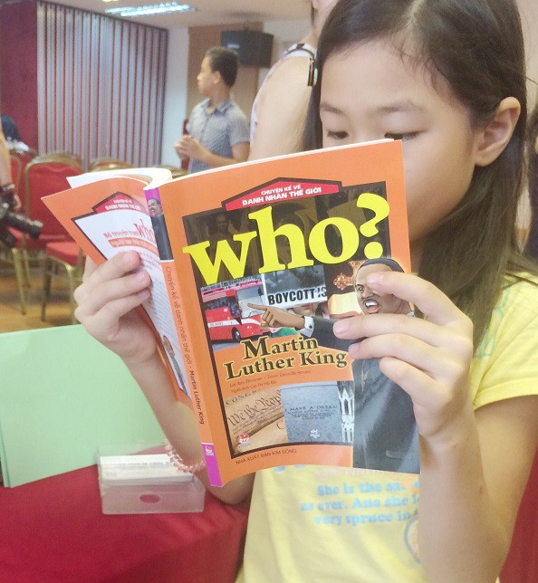 Hình ảnh một em bé say mê đọc sách tại hội thảo. (Ảnh: Ngọc Bích)