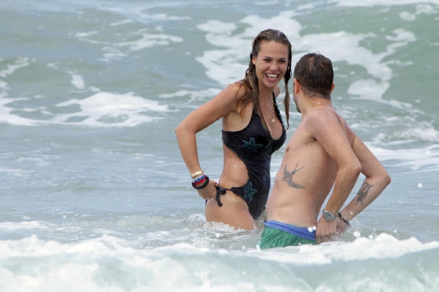 Bất ngờ một con sóng mạnh khiến chiếc quần bơi của cô bị tụt xuống, phơi bày một phần vòng ba của cô