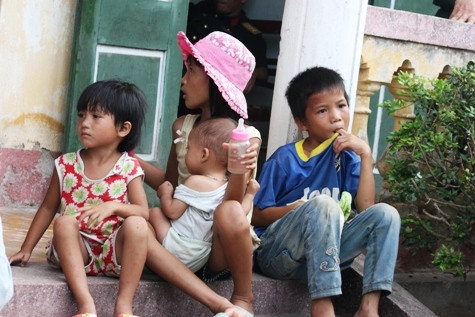 Những đứa trẻ dại bồng bế nhau tới hội trường xã Quảng Phúc. Hình như chúng chẳng hiểu gì về câu chuyện của những người lớn đang bàn cãi. Ngày mai, có thể các em sẽ không được đến trường vì chính quyền và cha mẹ chúng không tìm được sự thống nhất. Ảnh Xuân Quang.