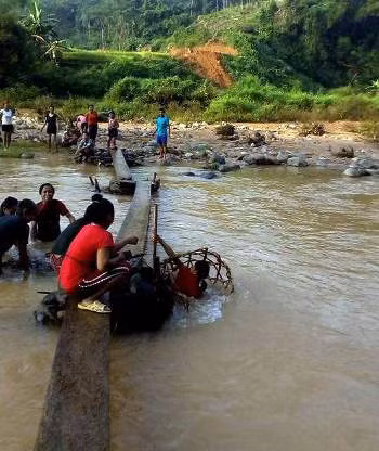 Mỗi khi nước lũ dâng cao, cầu tạm bị cuốn trôi, dân bản và giáo viên phải lội suối để sửa cầu. Ảnh tư liệu do giáo viên cung cấp.