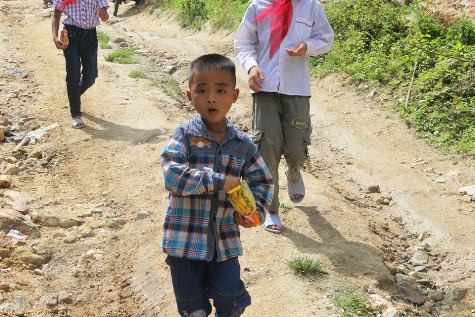 Mấy đứa trẻ xóm núi lếch thếch trên đường, tay cầm gói mỳ tôm bốc vội, vượt suối, leo đèo, háo hức tới trường. Ảnh: Xuân Quang. Mấy đứa trẻ xóm núi lếch thếch trên đường, tay cầm gói mỳ tôm bốc vội, vượt suối, leo đèo, háo hức tới trường. Ảnh: Xuân Quang.