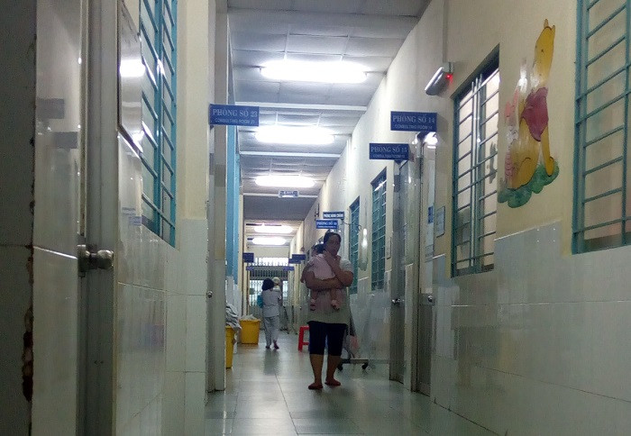 Bên ngoài hành lang của phòng bệnh, ông bố và bà mẹ trẻ vật vã dỗ dành con trẻ. Bên ngoài hành lang của phòng bệnh, ông bố và bà mẹ trẻ vật vã dỗ dành con trẻ.