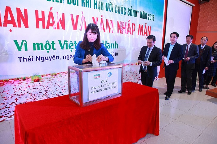 Các vị đại biểu và cán bộ, sinh viên trong trường cùng gây quỹ “Chung tay ứng phó với biến đổi khí hậu”.