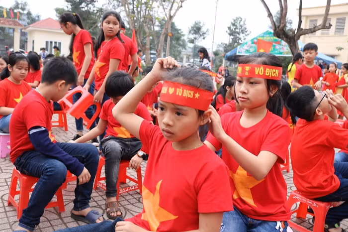 Một số em khác ngồi chỉnh lại trang phục để chuẩn bị tiếp sức cho đội tuyển U23 Việt Nam.