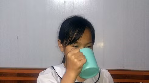 Bé Phương Anh cầm cái cốc ở nhà mô tả lại cái cốc tương tự em đã từng uống 1/2 nước giặt giẻ lau bảng ở lớp do cô giáo phạt. Ảnh: VOV. Bé Phương Anh cầm cái cốc ở nhà mô tả lại cái cốc tương tự em đã từng uống 1/2 nước giặt giẻ lau bảng ở lớp do cô giáo phạt. Ảnh: VOV.