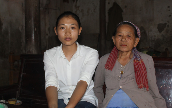 Em Nguyễn Thị Hoa và bà nội bên căn nhà cấp 4 cũ kỹ tại Thôn Duệ, xã Định Tiến, huyện Yên Định. Ảnh của Thảo Nguyên.