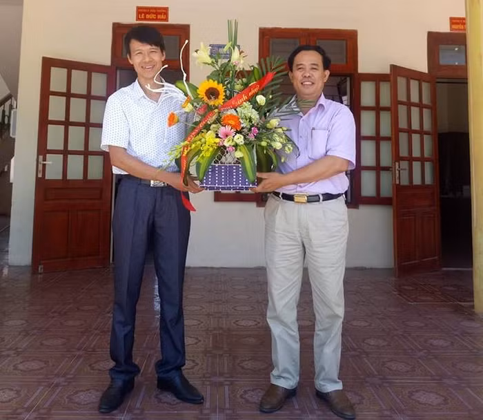 Thầy giáo Đỗ Thế Minh nhận hoa chúc mừng từ Hiệu trưởng Lê Văn Dỵ Ảnh của nhân vật cung cấp.