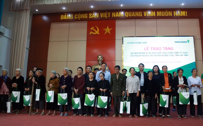 Ông Nghiêm Xuân Thành – Bí thư Đảng ủy, Chủ tịch Hội đồng quản trị Vietcombank (thứ 6 từ phải sang) cùng đại diện lãnh đạo tỉnh Hà Tĩnh tặng quà Tết cho hộ nghèo, hộ cận nghèo trên địa bàn huyện Hương Sơn, tỉnh Hà Tĩnh tại chương trình.