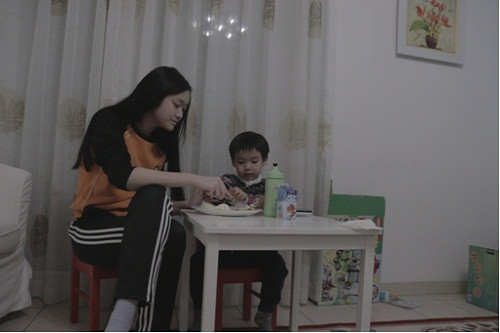 Mai học bài ở nhà chăm sóc em trai lúc rảnh rỗi.