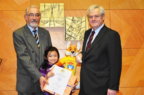 Thanh Mai 7 tuổi đạt giải vô địch toán tỉnh Unterfranken. Trong ảnh là Chủ tịch tỉnh Unterfranken Dr. P. Beinhofer và Chủ tịch nhà Bank, Bezirkspräsident K. Hippeli, RV Bank, nhà tài trợ cho cuộc thi.