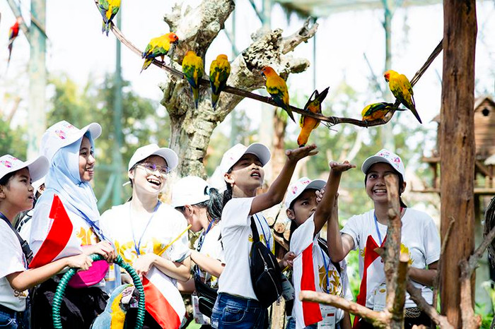 Các đại biểu nhí Indonesia đùa vui với vẹt Nam Mỹ.