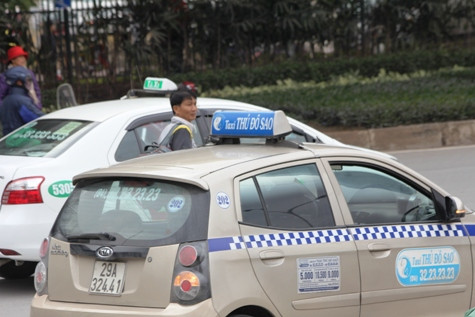 Một người đàn ông mắc kẹt giữa hai chiếc taxi trên đường Phạm Hùng khi anh này cố tình băng qua đường, bất chấp đèn tín hiệu (ảnh: THỤY DU).