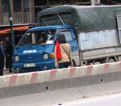 Người phụ nữ vượt rào chắn, băng qua đường Phạm Văn Đồng (ảnh: THỤY DU).