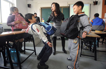 Học sinh đeo ba lô đằng trước để hiểu sự khó khăn của phụ nữ khi mang bầu.