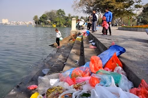 Thả cá chép, thả cả túi nilông (Ảnh: Trần Kháng)