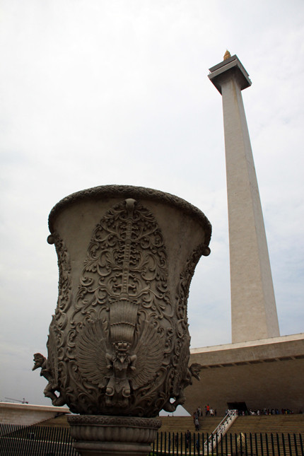 Monas là thiết của kiến trúc sư Frederich Silaban với cảm hứng từ triết lý phồn thực. Công trình có tổng chiều cao là 132m gồm một trụ cột cao 117,7m, tượng trưng cho Linga (vật trưng nam giới) và một bệ đỡ hình thang hộp úp ngược, với chiều dài các cạnh đáy là 45m, tượng trưng cho Yoni (vật trưng nữ giới). Monas chủ yếu được xây bằng đá cẩm thạch. Khu vực chân tượng đài, được quây vuông bởi những bức tường phù điêu, tái hiện cô đọng một tiến trình lịch sử của đất nước vạn đảo.