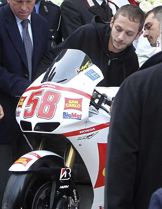 Valentino Rossi đưa chiếc xe số 58 huyền thoại của Marco Simoncelli vào nhà thờ, nơi đặt quan tài Simoncelli. Valentino Rossi đưa chiếc xe số 58 huyền thoại của Marco Simoncelli vào nhà thờ, nơi đặt quan tài Simoncelli.