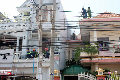 Hàng chục cán bộ chiến sĩ PCCC đang ra sức phá cửa để vào căn nhà đang phát hỏa