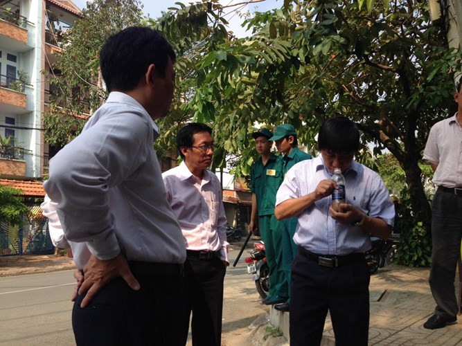 Ông Phan Minh Tân kiểm tra mẫu nước thu từ dưới hố đen