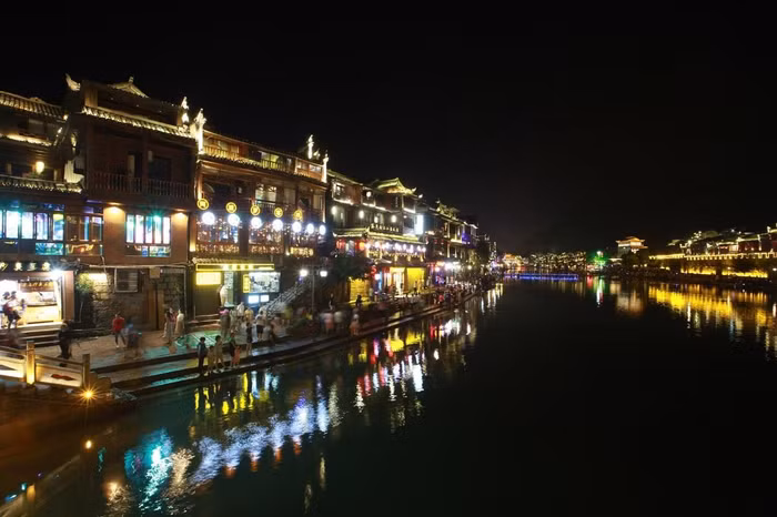 Đêm xuống, hai bên bờ của một khúc sông Đà Giang này luôn lung linh, huyền ảo. Theo tư liệu ghi chép, trấn Phượng Hoàng được xây dựng từ thời nhà Đường vào năm 686. Đến thời Minh - Thanh (1368 – 1644) nhanh chóng trở thành một trung tâm chính trị, văn hóa, quân sự lớn. Đây là nơi sinh sống chủ yếu của người Miêu, người Thổ Gia và người Hán.