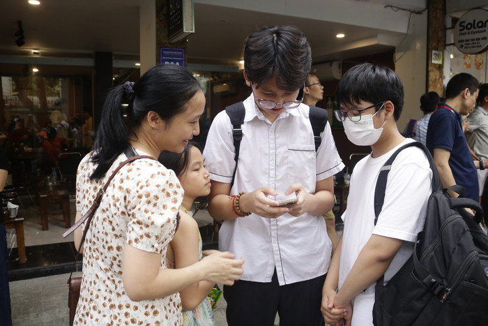 Em Bùi Nam Khánh đang cầm điện thoại để kiểm tra kết quả xem câu hỏi khó trong bài thi tiếng Anh em làm đúng hay chưa. (Ảnh: Ngọc Mai) GDVN (558).JPG