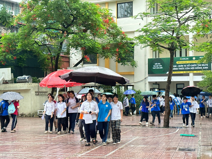 Các tình nguyện viên che ô để đưa thí sinh đến phòng thi. (Ảnh: Đào Hiền) Các tình nguyện viên che ô để đưa thí sinh đến phòng thi. (Ảnh: Đào Hiền)