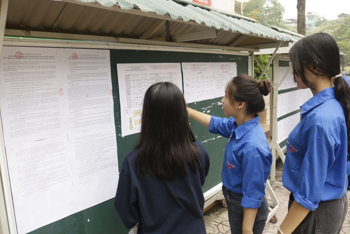 Tình nguyện viên hướng dẫn thí sinh tìm phòng thi. (Ảnh: Ngọc Mai) GDVN .JPG