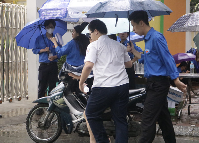 Một thí sinh đến muộn và được tình nguyện viên hỗ trợ. (Ảnh: Ngọc Mai) GDVN (24).JPG