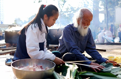 Những người thầy vĩ đại luôn biết cách truyền cảm hứng cho học trò. Trong ảnh là PGS.Văn Như Cương ở tuổi 80 vẫn tận tình dạy học trò cách gói bánh chưng. ảnh: Văn Thùy Dương.