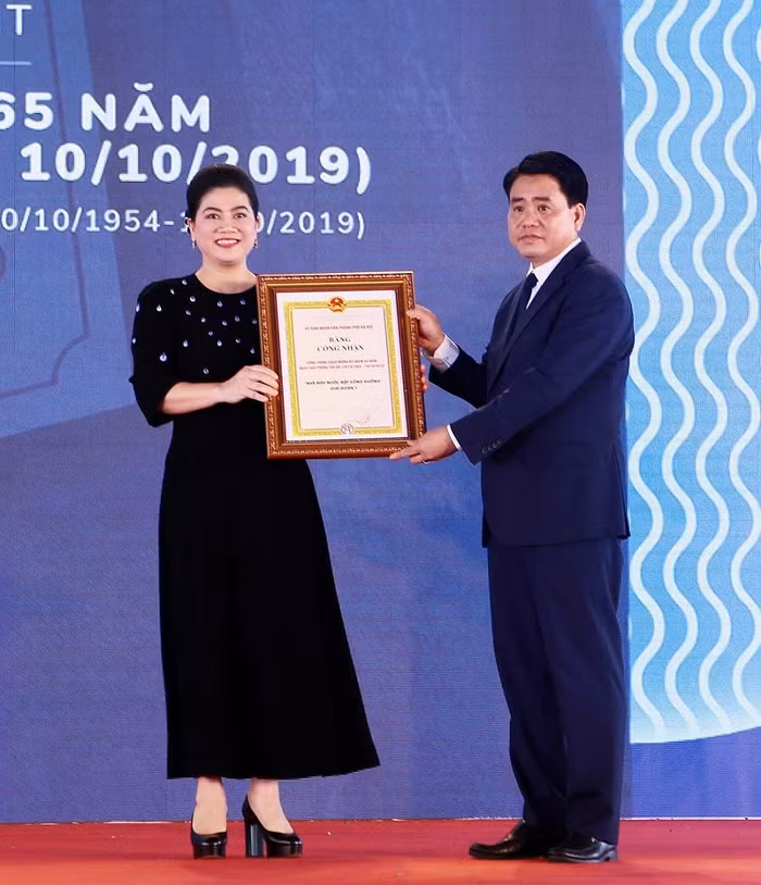 Chủ tịch Ủy ban nhân dân Thành phố Hà Nội trao Bằng công nhận Công trình chào mừng kỷ niệm 65 năm Ngày giải phóng Thủ đô cho bà Đỗ Thị Kim Liên - Chủ tịch Hội đồng quản trị Công ty cổ phần nước mặt sông Đuống. ảnh: QT.