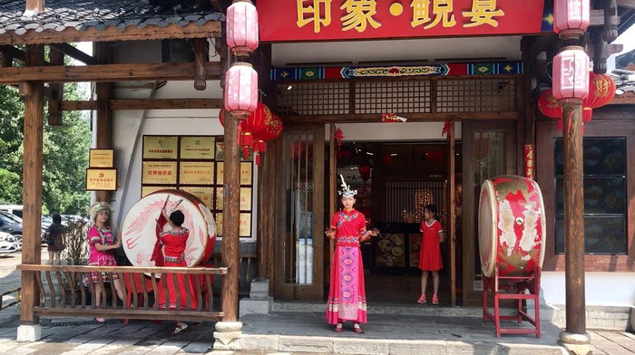 Tại Nhà hàng &quot;Ấn Tượng Lê Tục&quot; thuộc quận Vũ Lăng Nguyên (tỉnh Hồ Nam) có trình diễn phong tục uống rượu theo phong cách truyền thống của người Thổ Gia. Khi khách chuẩn bị bước tới cửa thì các cô gái đánh trống và mời rượu, hát mừng đón khách.