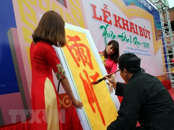 Cụ đồ nho cao tuổi khai bút. (Ảnh: Mạnh Tú/TTXVN)