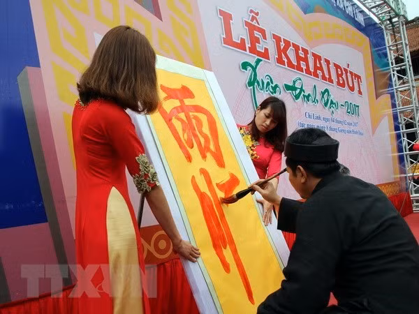 Cụ đồ nho cao tuổi khai bút. (Ảnh: Mạnh Tú/TTXVN)