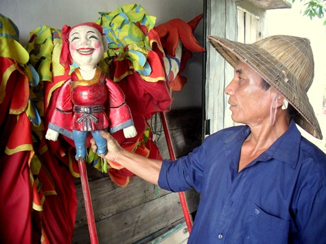 Một nghệ nhân múa rối bên cạnh chú Tễu. Ảnh: Ngọc Khánh