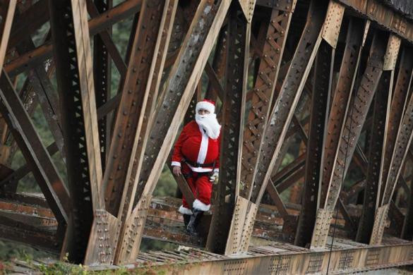 Lính cứu hỏa Hector Chacon trong trang phục ông già Noel đang tặng đồ chơi cho trẻ em sống tại khu vực gầm cầu ở thành phố Guatemala City, Guatemala ngày 23/12.