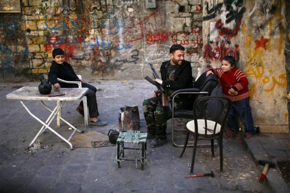 Một tay súng nổi dậy Syria đang đùa vui với một em bé tại Aleppo ngày 27/12.